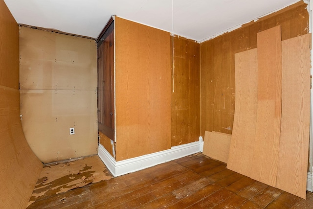 empty room with wood walls and wood-type flooring