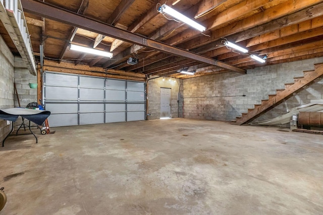 garage with a garage door opener and concrete block wall