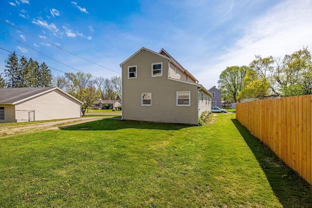back of property featuring fence and a yard