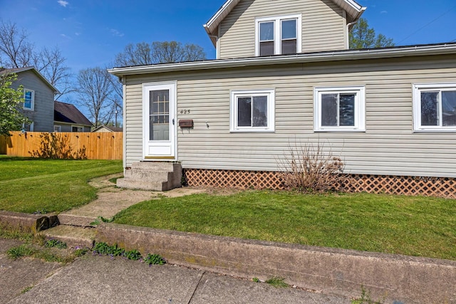 exterior space with fence, entry steps, and a yard