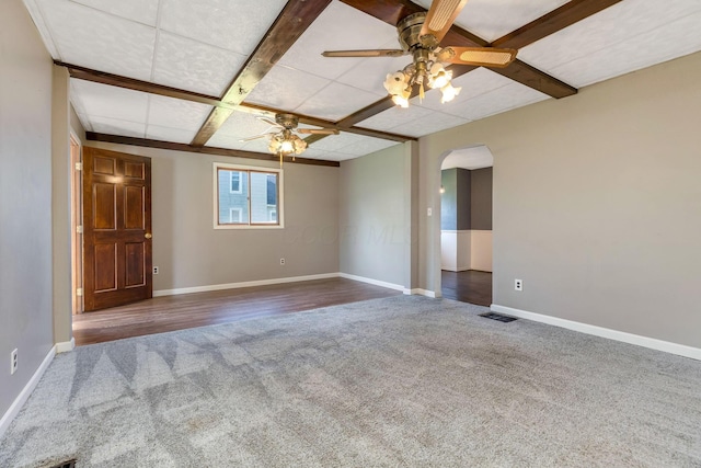 spare room featuring baseboards, arched walkways, ceiling fan, and carpet flooring