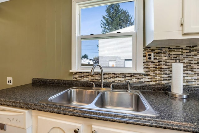 details featuring decorative backsplash, white cabinetry, dishwasher, and a sink