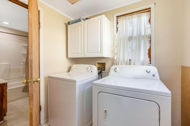 washroom with washing machine and clothes dryer, cabinet space, and crown molding