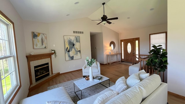 living room featuring visible vents, a ceiling fan, and a wealth of natural light