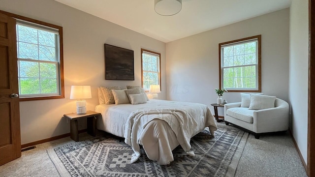 bedroom featuring carpet flooring, baseboards, and multiple windows