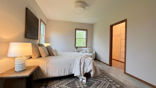 bedroom with baseboards and carpet