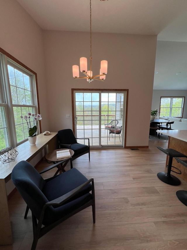 sitting room with an inviting chandelier and light wood-style floors