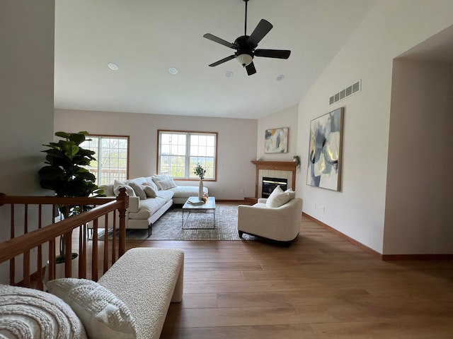 living area with visible vents, baseboards, ceiling fan, and wood finished floors