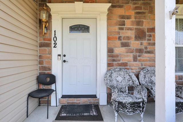 doorway to property with brick siding
