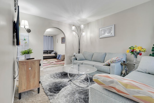 carpeted living room featuring arched walkways