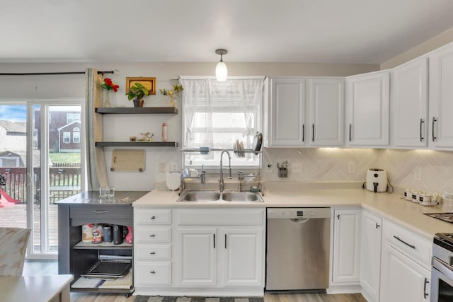 kitchen with a sink, white cabinets, backsplash, and stainless steel appliances