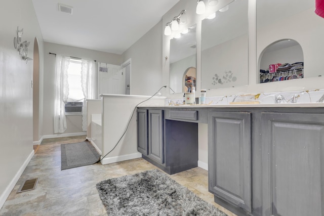 full bathroom featuring double vanity, visible vents, and baseboards