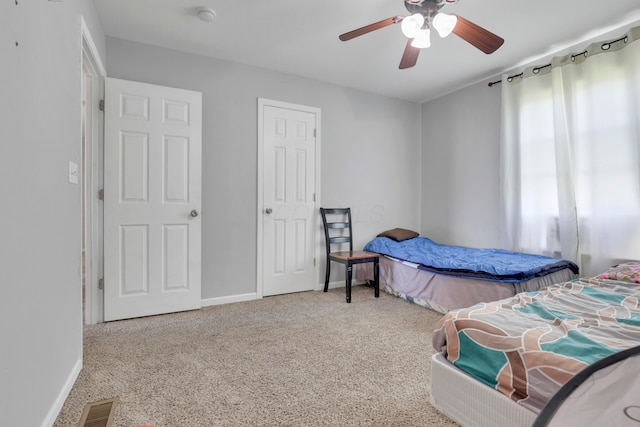 bedroom with carpet floors, visible vents, ceiling fan, and baseboards