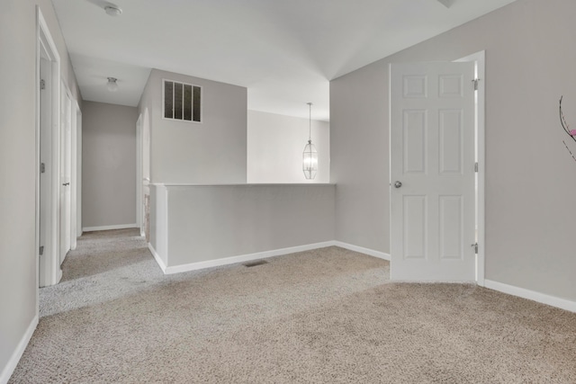 spare room featuring baseboards, visible vents, and carpet floors