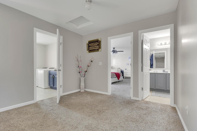 corridor featuring attic access, baseboards, and light carpet