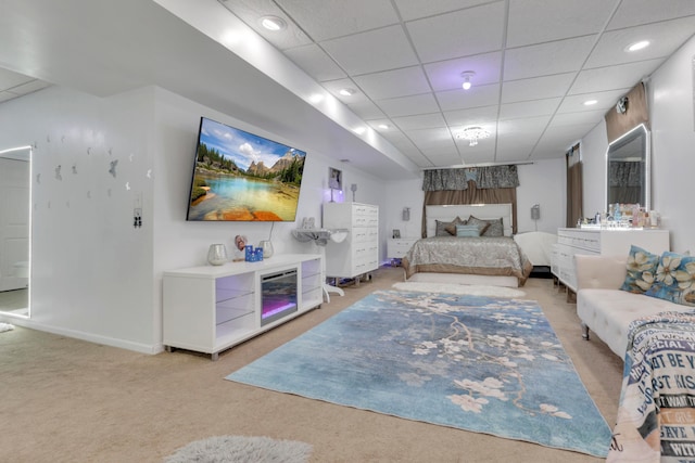 living room with baseboards, recessed lighting, light colored carpet, and a drop ceiling