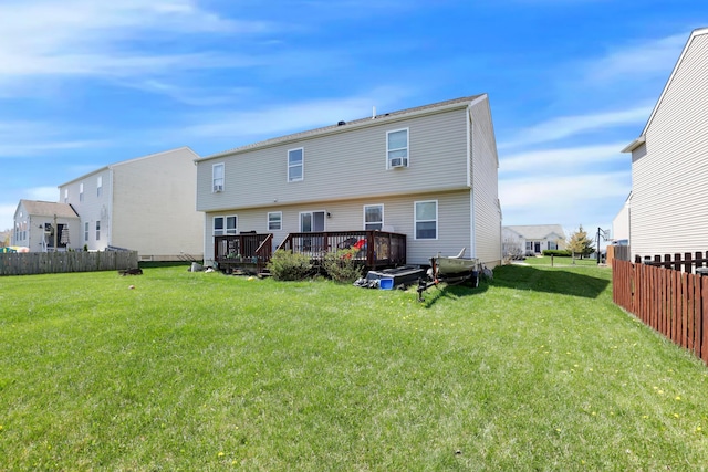 rear view of property featuring cooling unit, a lawn, a wooden deck, and fence