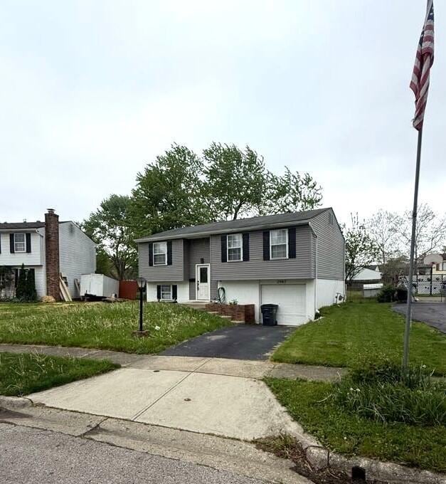 bi-level home featuring driveway, a front yard, and a garage