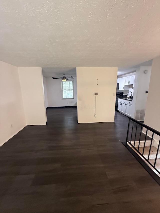 hall with baseboards, stairway, dark wood-style floors, visible vents, and a textured ceiling
