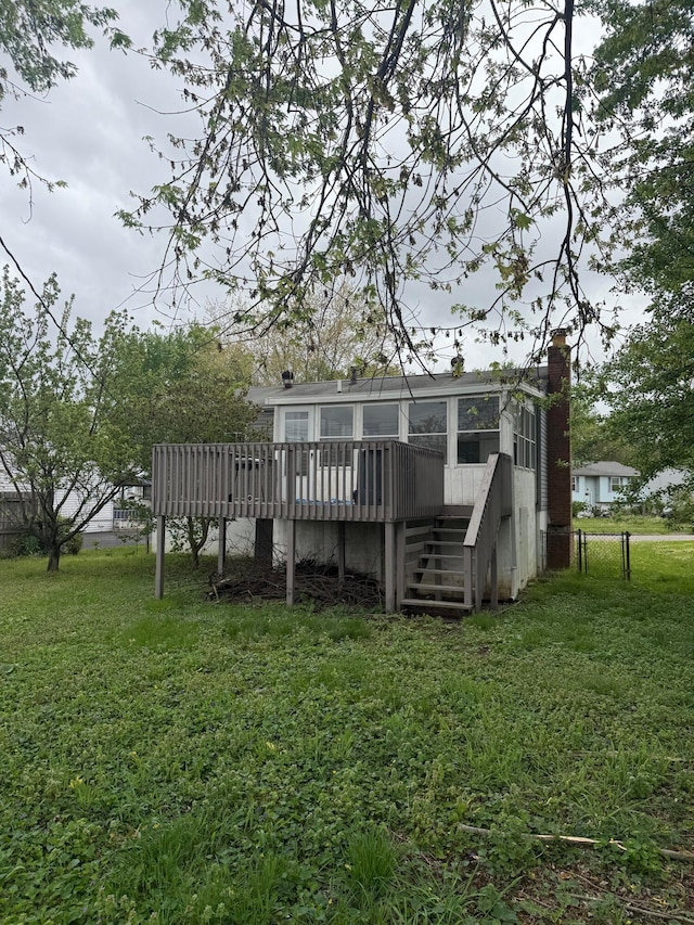 back of house with a deck, a yard, stairs, and a chimney