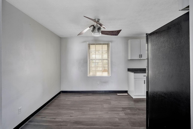 2987 Olivette Rd, Columbus, OH 43232 - unfurnished dining area with a ceiling fan, a textured ceiling, dark wood-type flooring, and baseboards