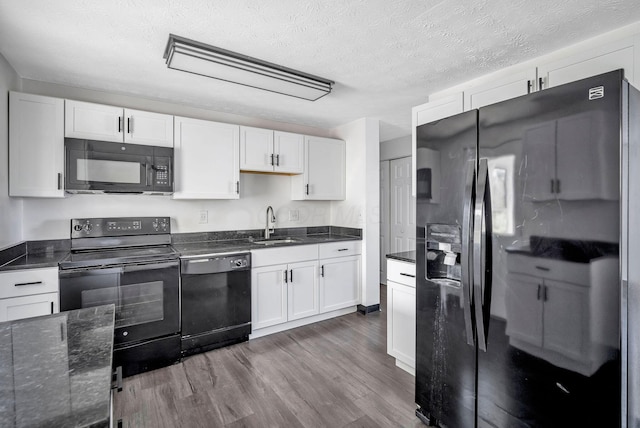 2987 Olivette Rd, Columbus, OH 43232 - kitchen with black appliances, dark wood finished floors, a sink, white cabinets, and a textured ceiling