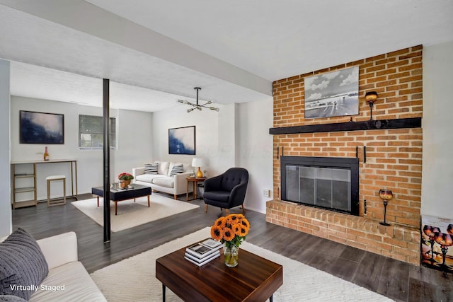 2987 Olivette Rd, Columbus, OH 43232 - living area featuring wood finished floors, a brick fireplace, and a chandelier