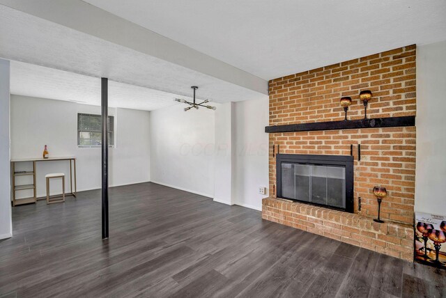 2987 Olivette Rd, Columbus, OH 43232 - unfurnished living room featuring wood finished floors, a brick fireplace, baseboards, and a chandelier