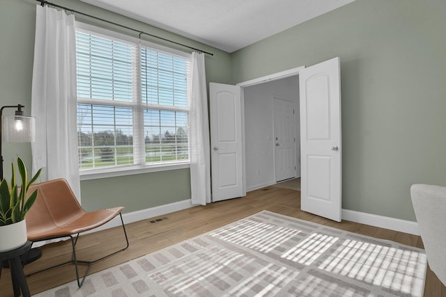 sitting room featuring baseboards, wood finished floors, and visible vents