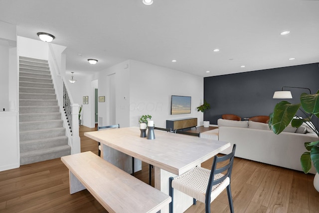 dining space with light wood-style floors, recessed lighting, and stairway