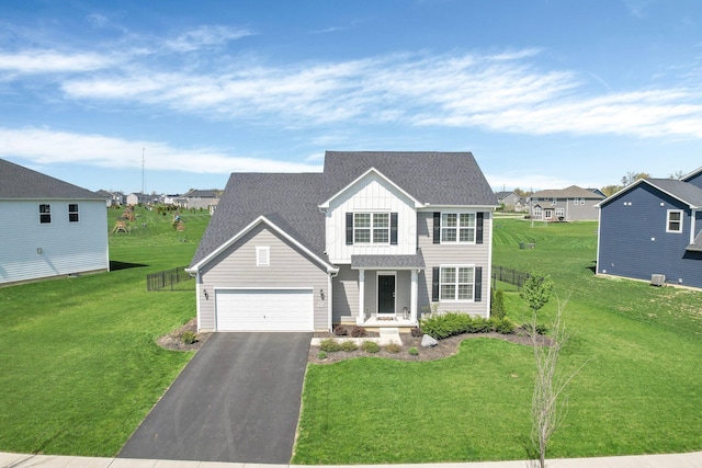 view of front facade with board and batten siding, an attached garage, driveway, and a front yard