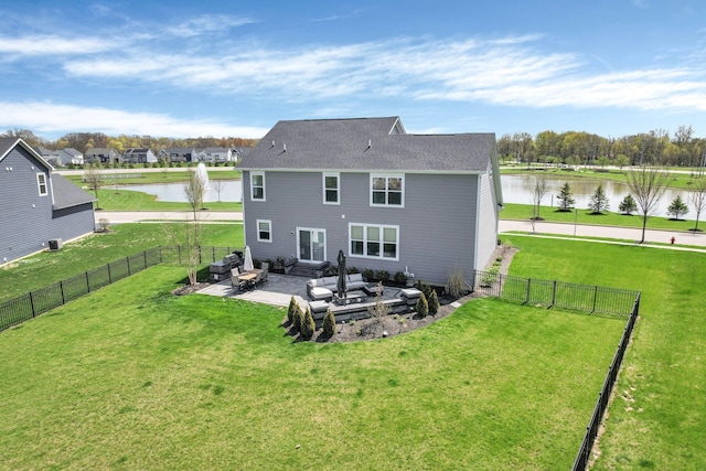 rear view of house featuring a yard, a water view, a fenced backyard, and a patio area