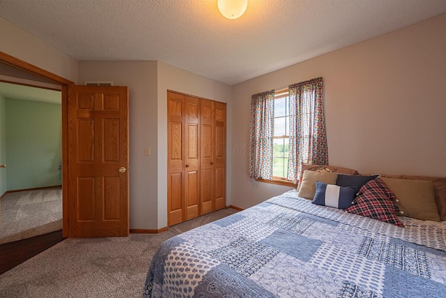 carpeted bedroom with a closet, a textured ceiling, visible vents, and baseboards