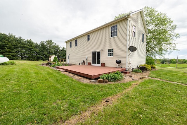 rear view of property featuring a wooden deck and a lawn