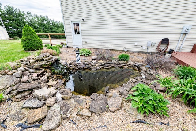 exterior space featuring a wooden deck and a garden pond