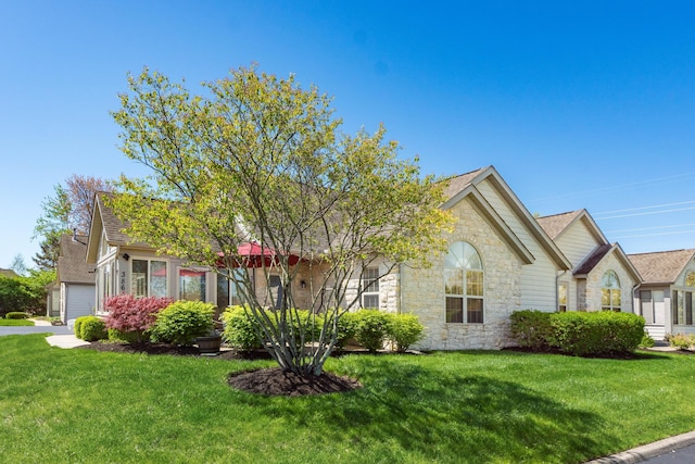 view of front of property featuring a front lawn and stone siding