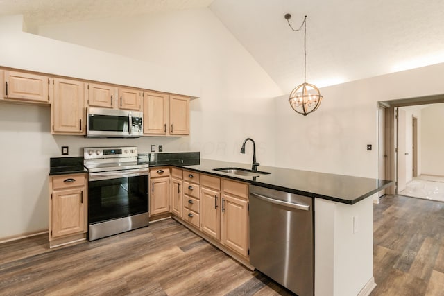 kitchen with a sink, light brown cabinetry, dark countertops, and stainless steel appliances