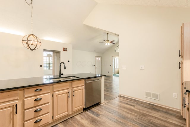 kitchen featuring visible vents, light brown cabinets, a sink, dishwasher, and vaulted ceiling
