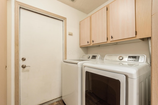 clothes washing area with cabinet space and washing machine and dryer