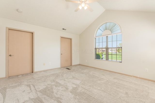 carpeted spare room with baseboards, ceiling fan, lofted ceiling, and visible vents