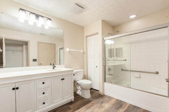 full bathroom featuring vanity, toilet, wood finished floors, and a closet