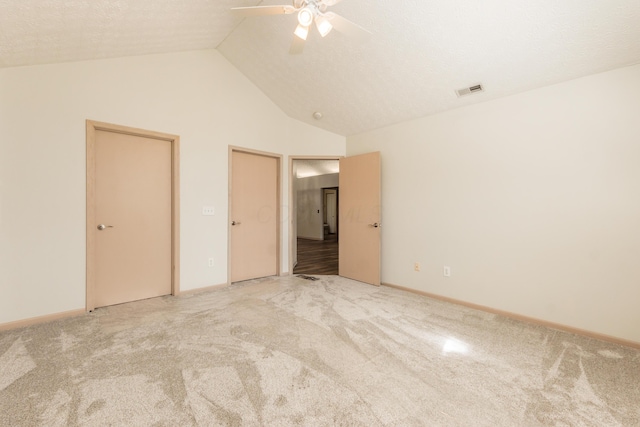 unfurnished bedroom with a ceiling fan, visible vents, baseboards, high vaulted ceiling, and carpet flooring