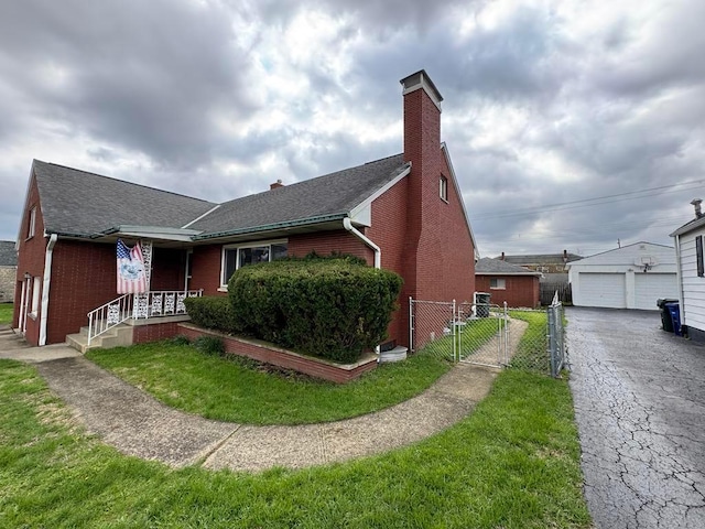 view of front facade with a front lawn, roof with shingles, a chimney, brick siding, and a gate