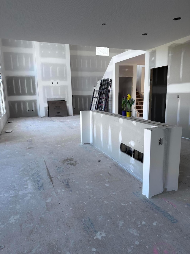 unfurnished living room featuring stairway