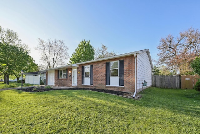 single story home featuring fence, brick siding, and a front yard