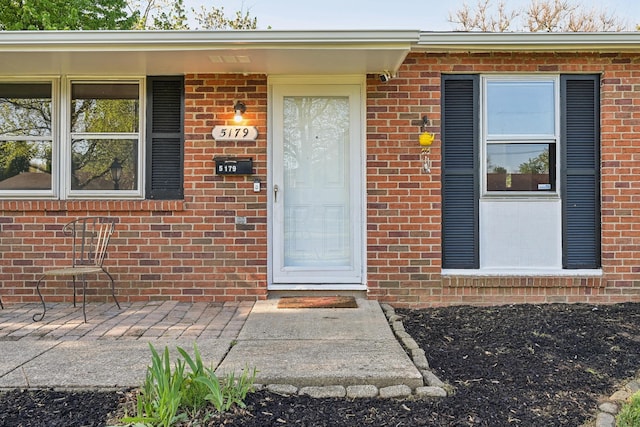 view of exterior entry featuring brick siding