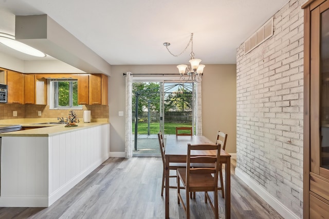 dining space featuring baseboards, plenty of natural light, and light wood finished floors