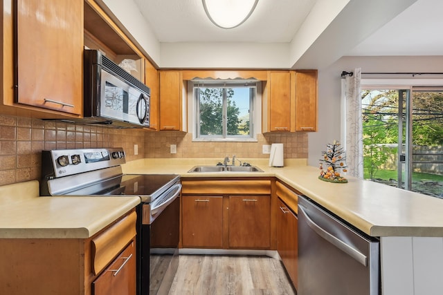 kitchen featuring a sink, light countertops, plenty of natural light, and stainless steel appliances