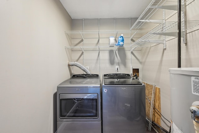 clothes washing area featuring independent washer and dryer, laundry area, and gas water heater