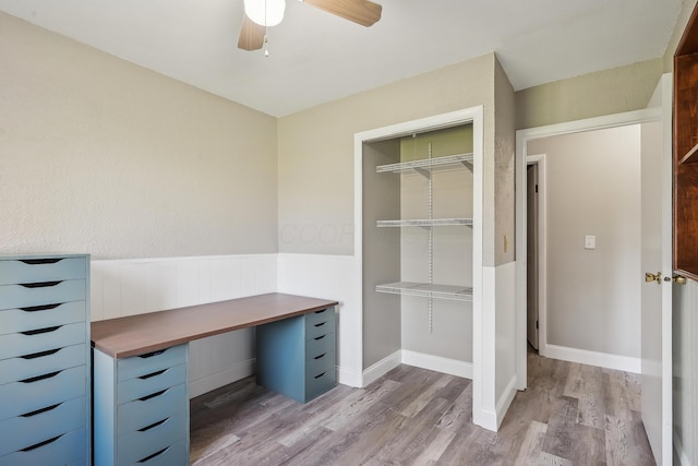 unfurnished office with a ceiling fan and light wood-style flooring